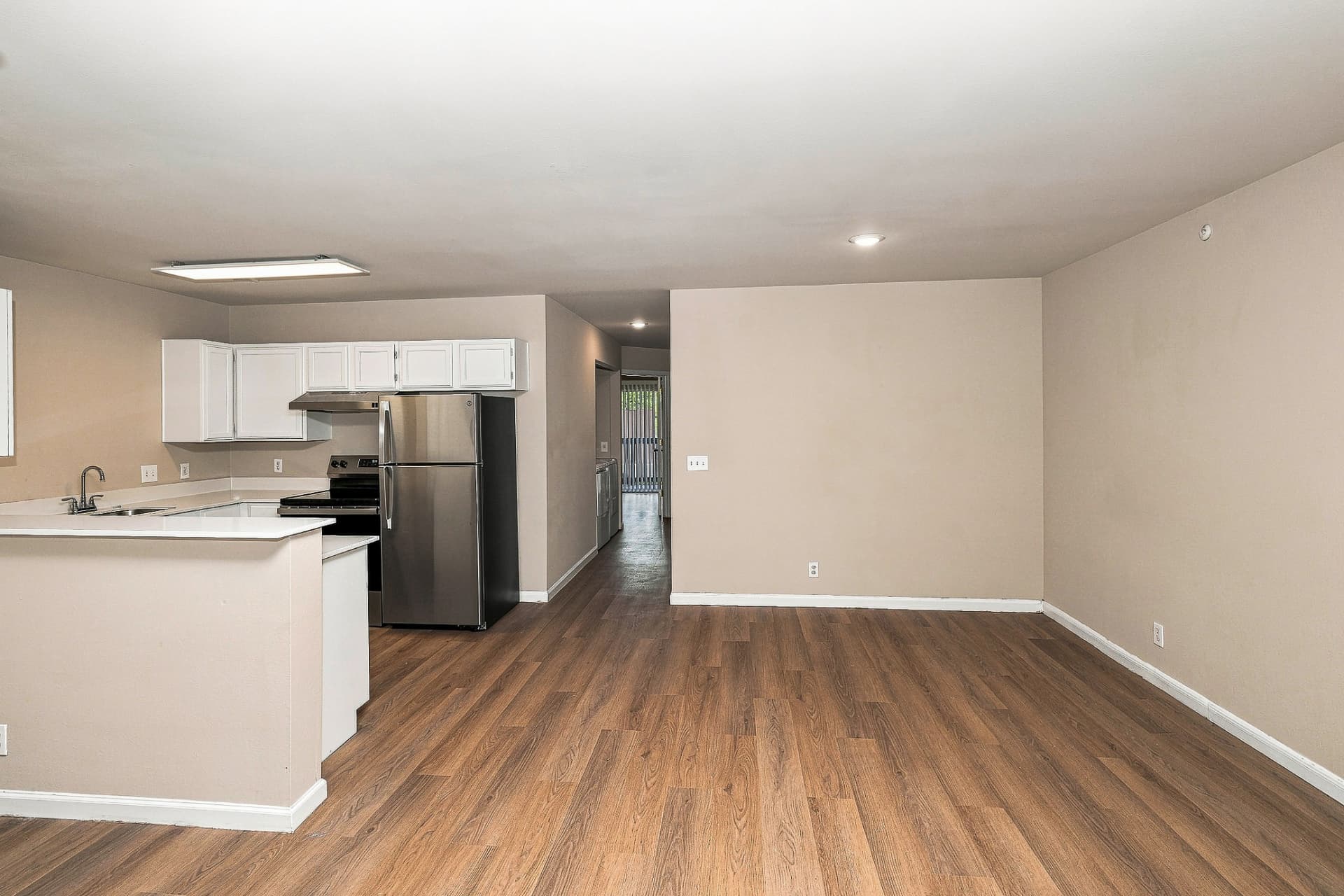 Renovated dining area open to the kitchen with white cabinetry and stainless appliances