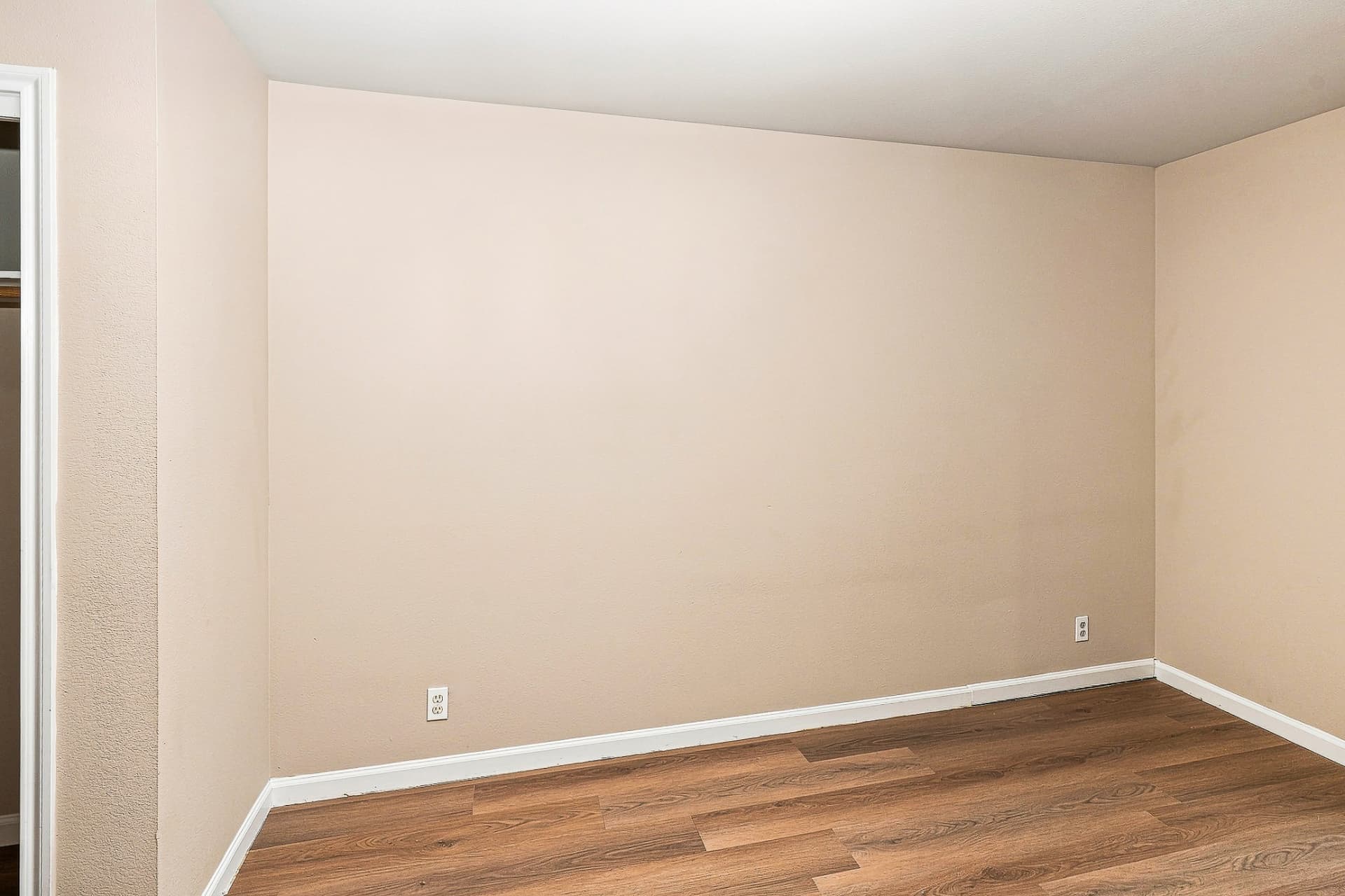 Renovated bedroom with wood-look flooring and window blinds