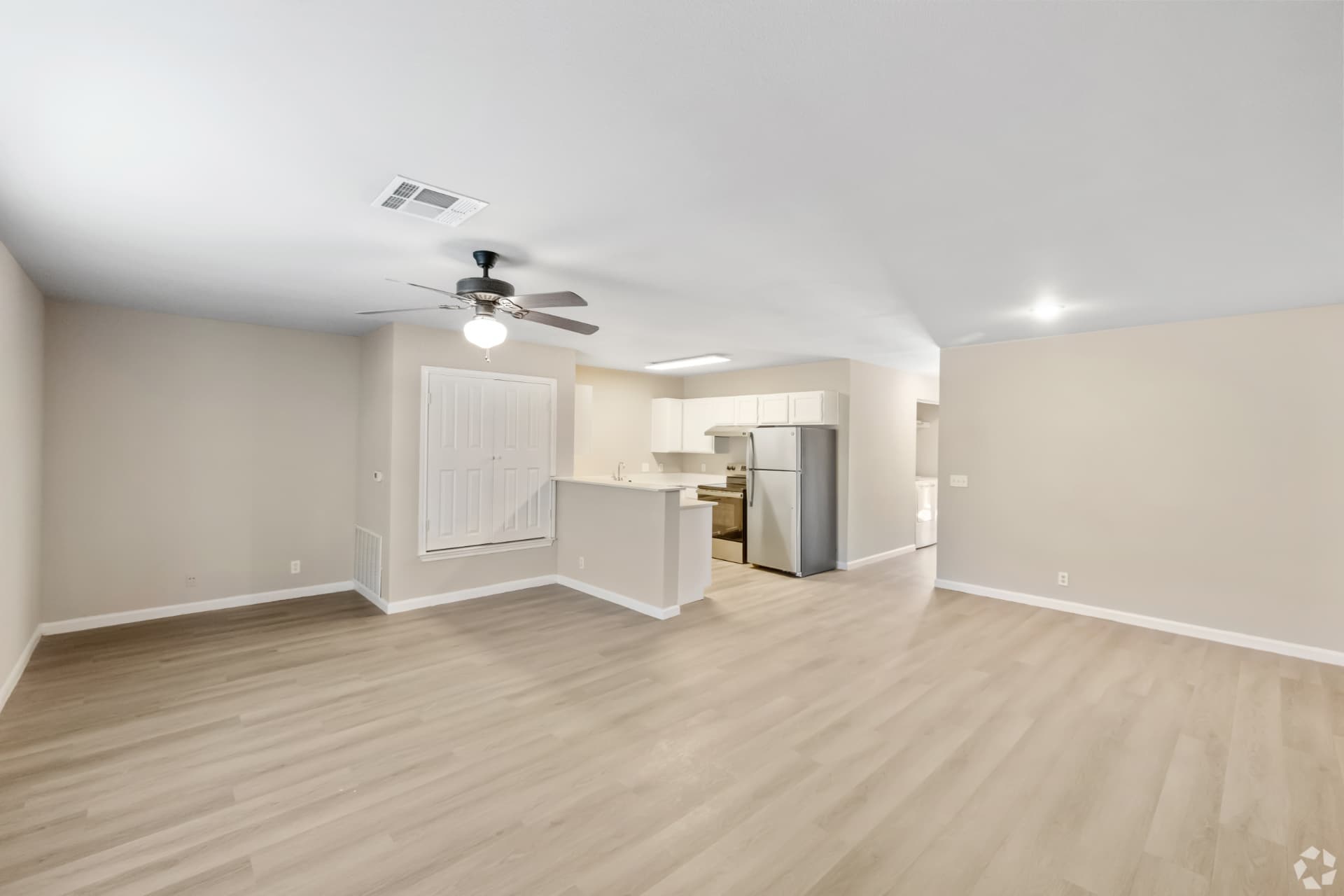 Renovated living room open to the kitchen with wood-look flooring