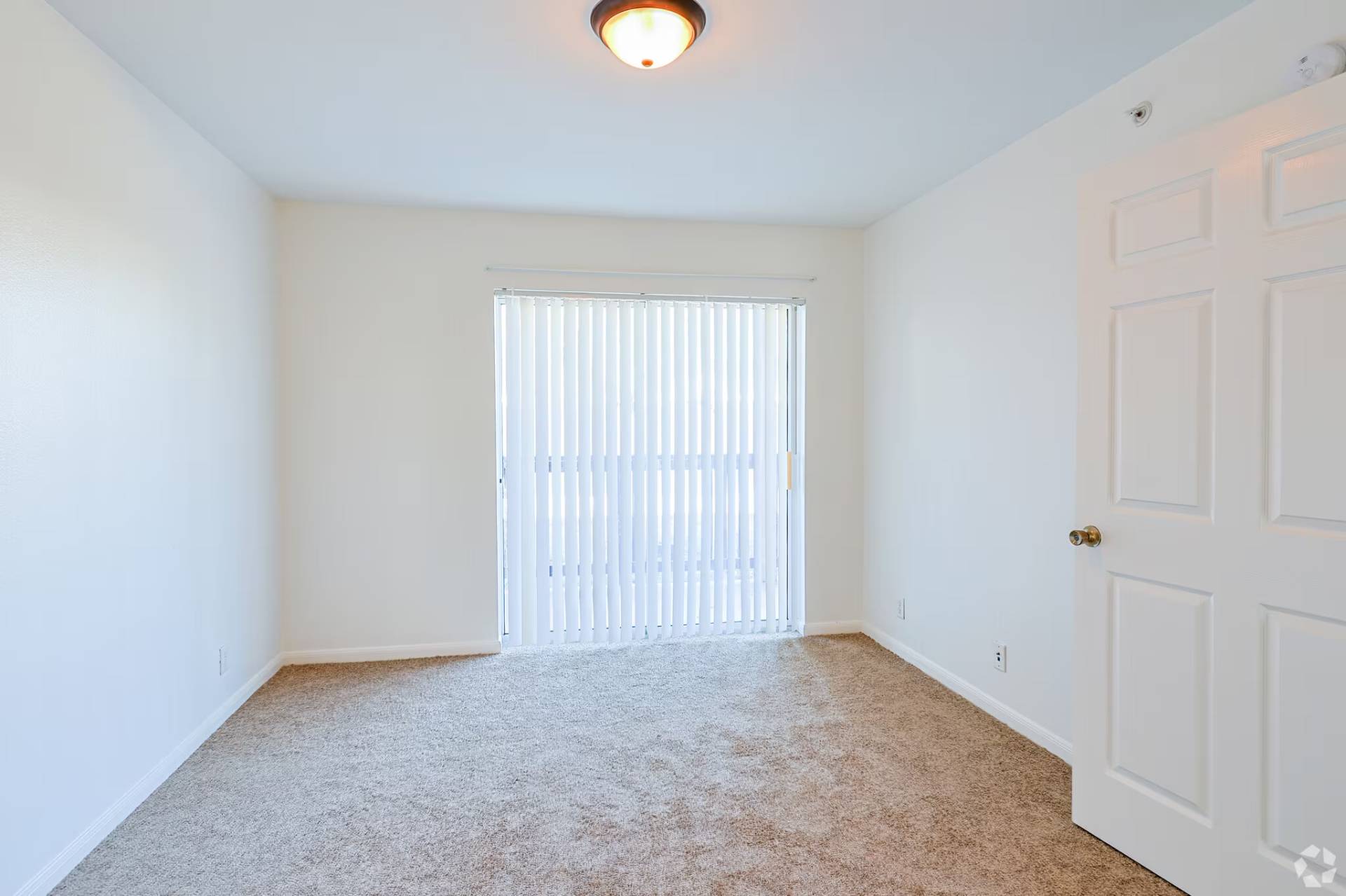 Classic-finish bedroom with vertical blinds and fresh carpet