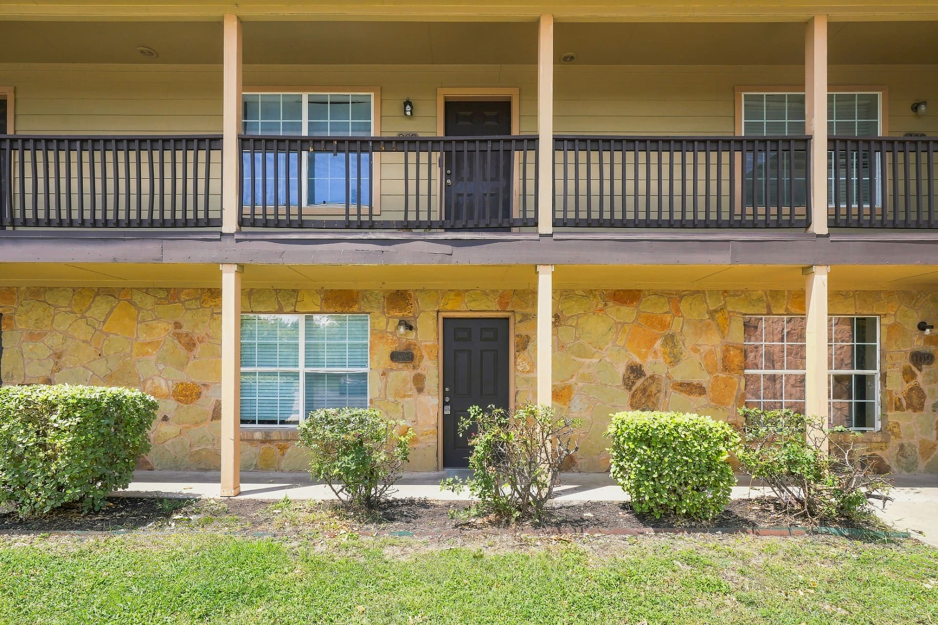 Front view of a Montierra Ranch building with stone base and covered entries