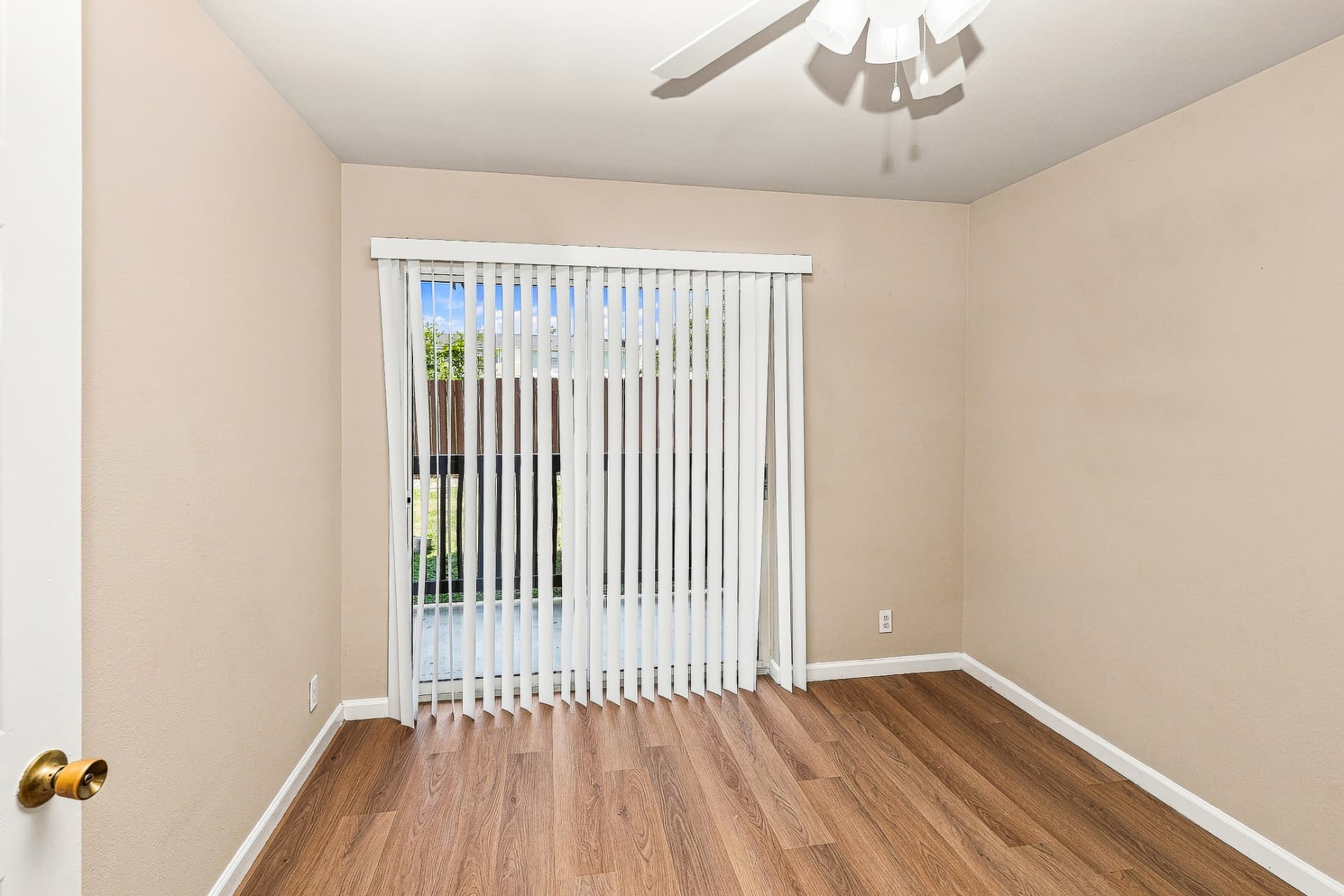 Renovated bedroom with ceiling fan and patio-door access