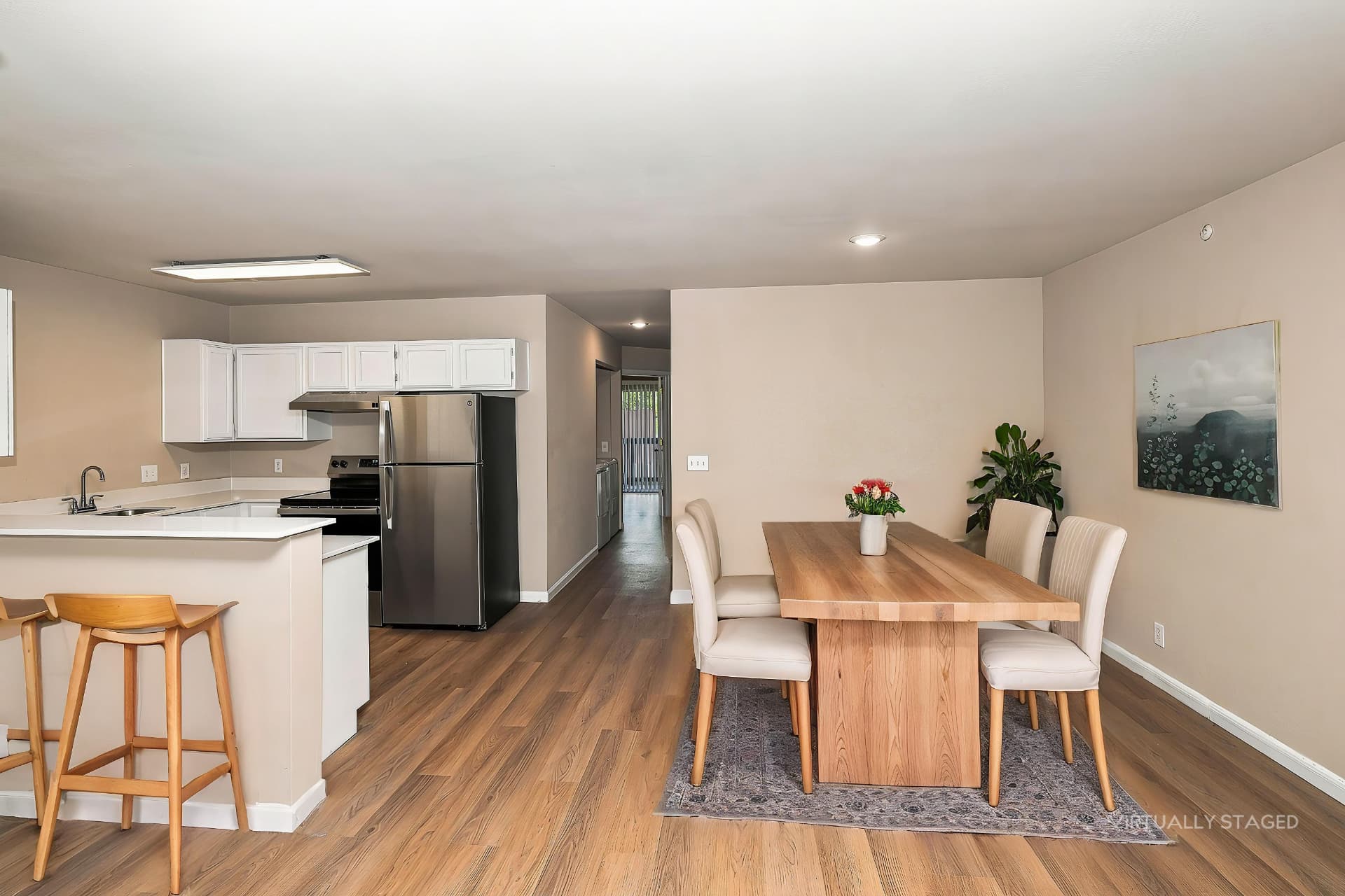 Renovated dining area shown with a table and seating (virtually staged)