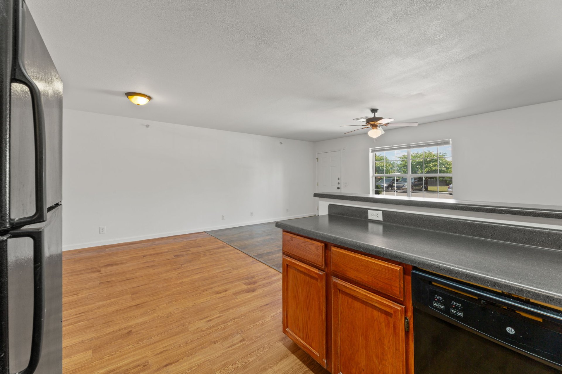 Classic-finish kitchen with oak cabinets, fridge, and breakfast bar opening to the living area