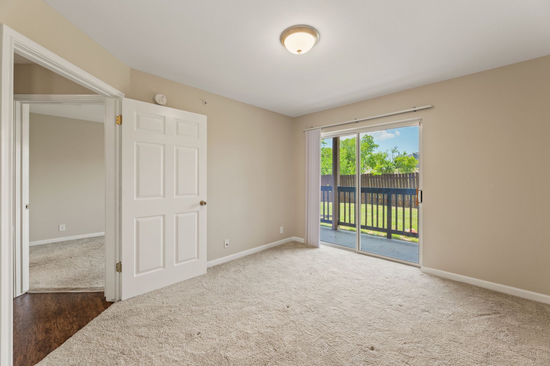 Second bedroom with patio sliding doors and fresh carpet