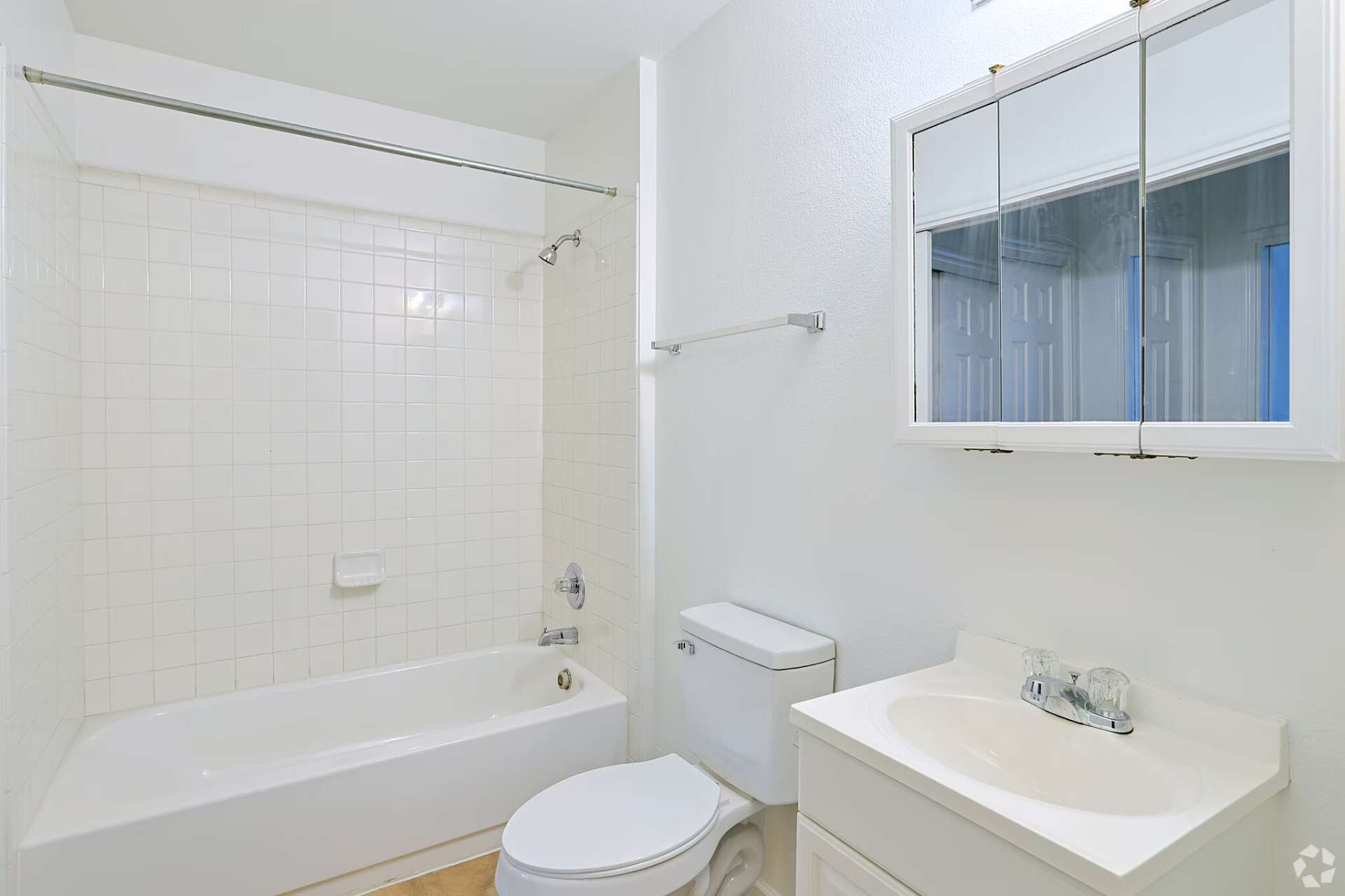 Classic-finish bathroom with tub, toilet, and medicine-cabinet vanity