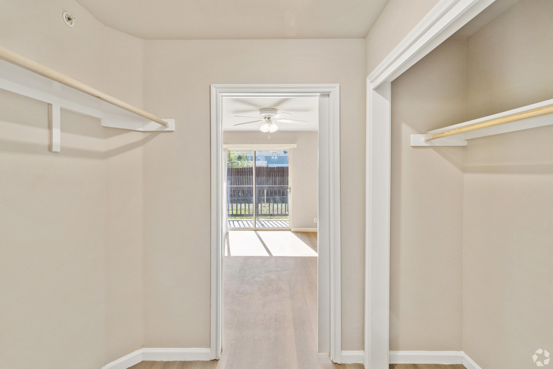 Walk-through closet with upper shelves and hanging rods on both sides