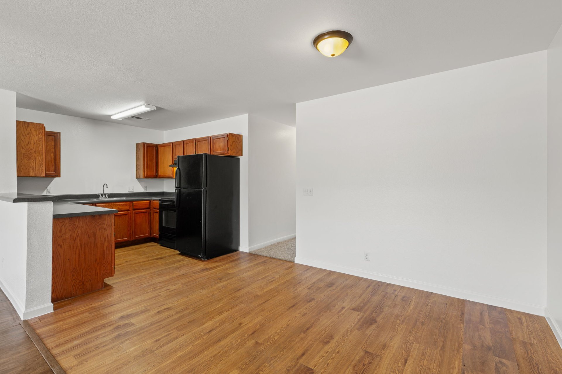 Classic-finish kitchen and dining area with oak cabinets and black appliances