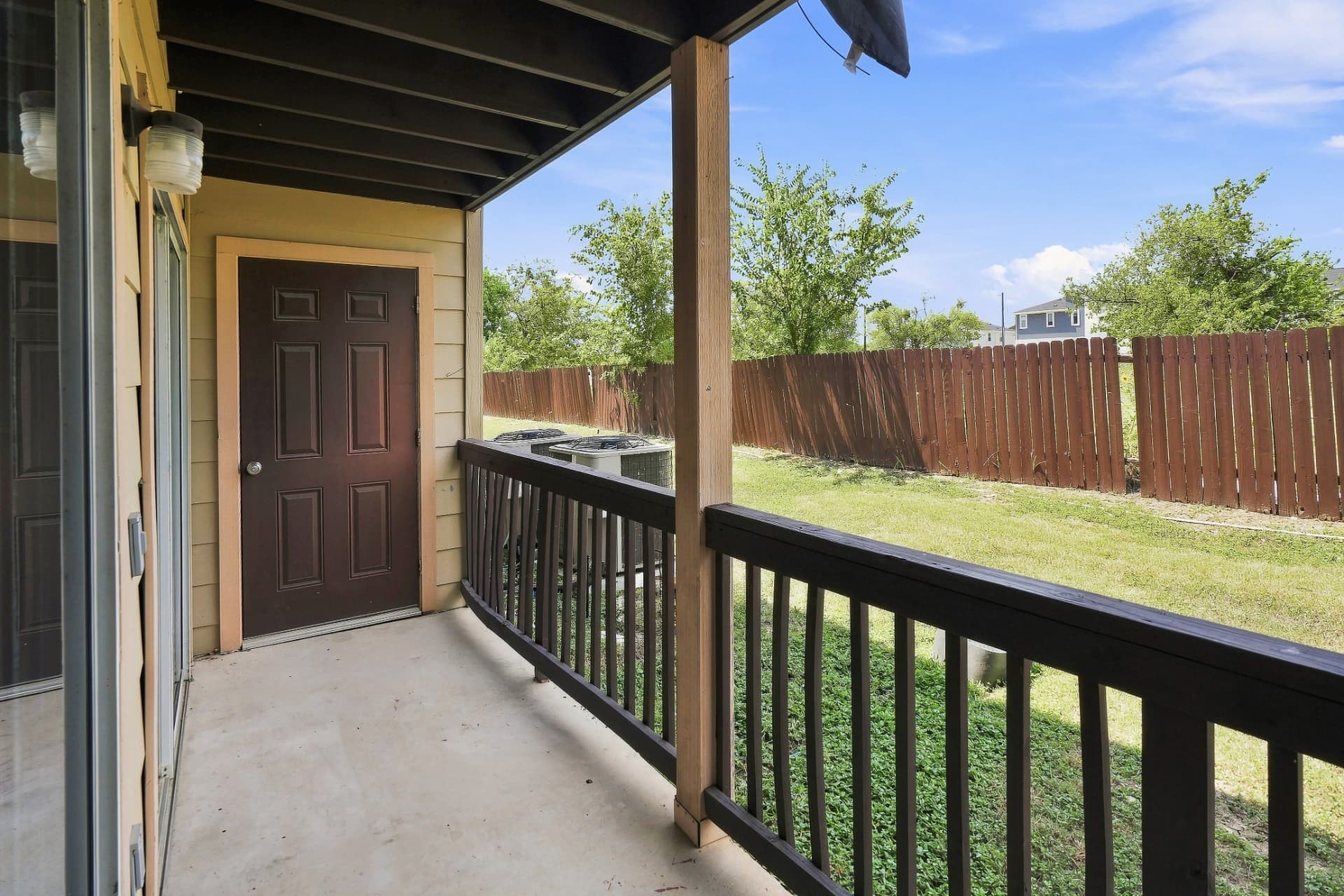 Private covered porch with fenced yard at a renovated home